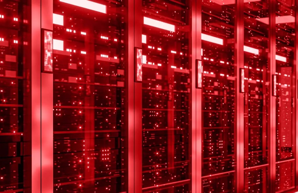 Reihe von Server-Racks mit leuchtenden roten LED-Lichtern in einem Rechenzentrum. Darstellung von Backbone-Infrastruktur, Netzwerktechnik und Datenübertragung.